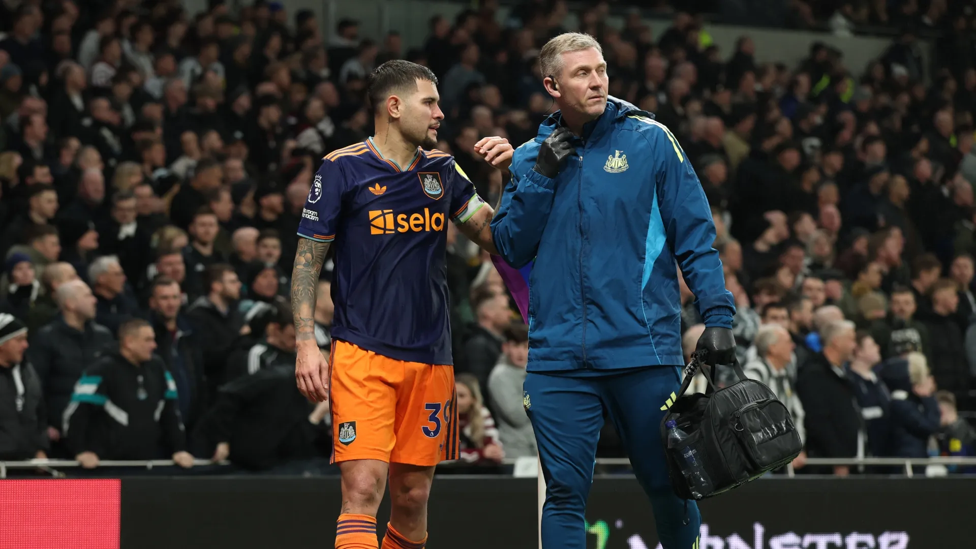 Bruno Guimaraes, del Newcastle United, sale del campo con un miembro del personal médico.