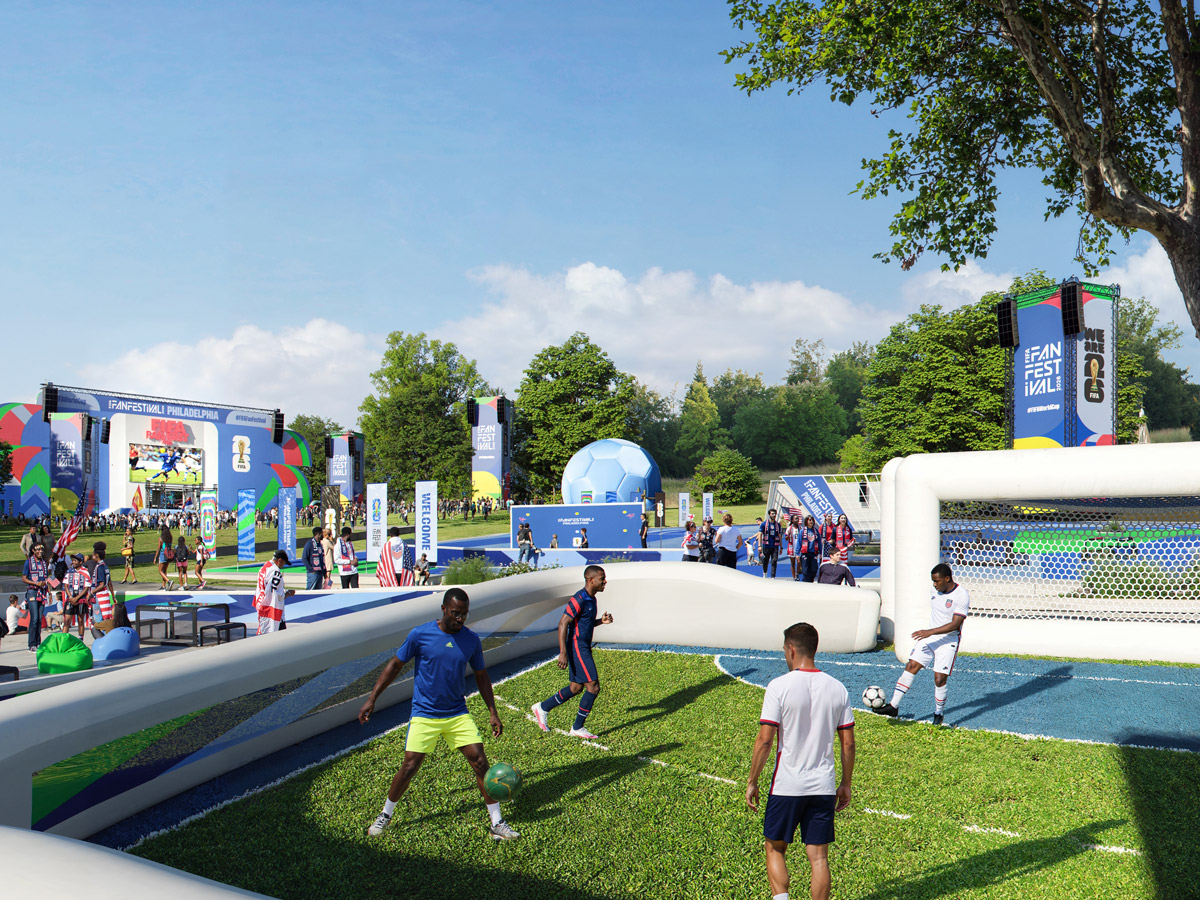 Durante el Festival de Fanáticos de la Copa Mundial de la FIFA 2026 en Filadelfia, los visitantes juegan fútbol informal en un campo pequeño con la multitud, actividades interactivas y un gran escenario visible al fondo.