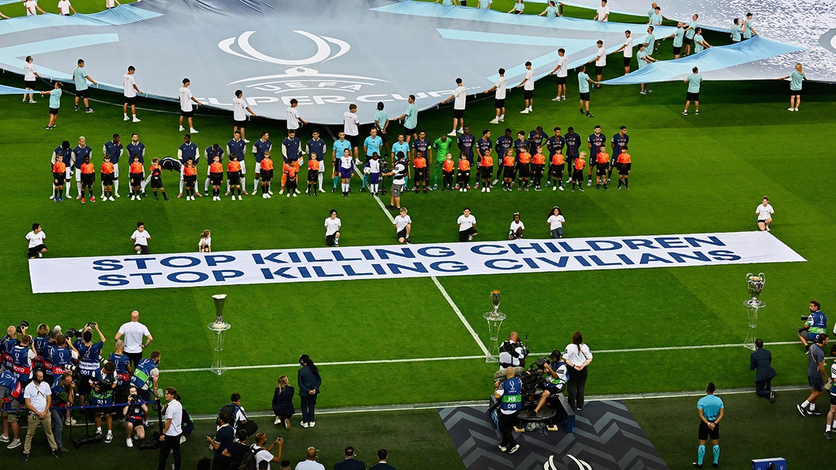 Los jugadores del Paris Saint-Germain y del Tottenham Hotspur se alinean antes del partido de fútbol en Udine, Italia.